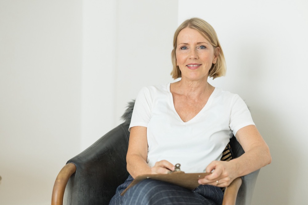Kirsten Thagaard sitzt in ihrer Praxis und lächelt